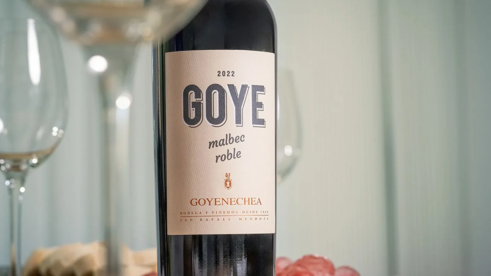 Goye Malbec wine bottle on a table with wine glasses and snacks