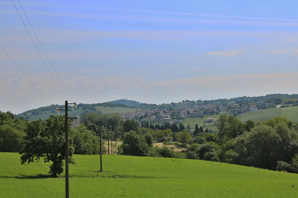 Green hill and a small village at the bottom