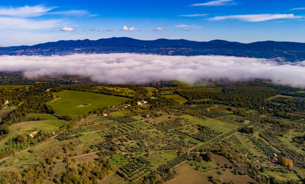 Green valley and blue hills with clouds above landscape