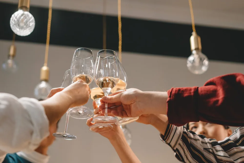 Group of friends celebrating with a toast of wine glasses indoors