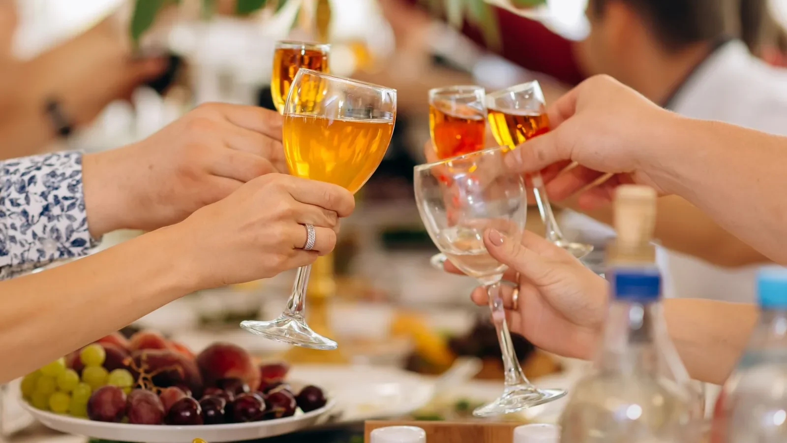 Hands toasting with wine glasses during a festive gathering