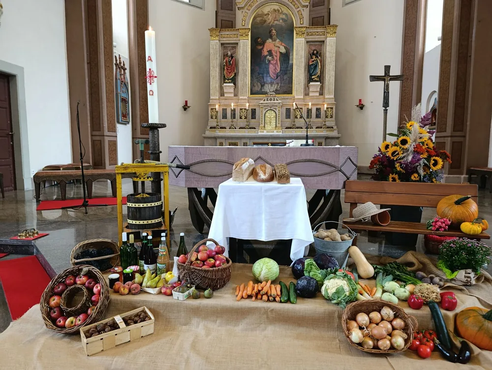 Harvest festival display with fruits, vegetables, and altar decorations in a church