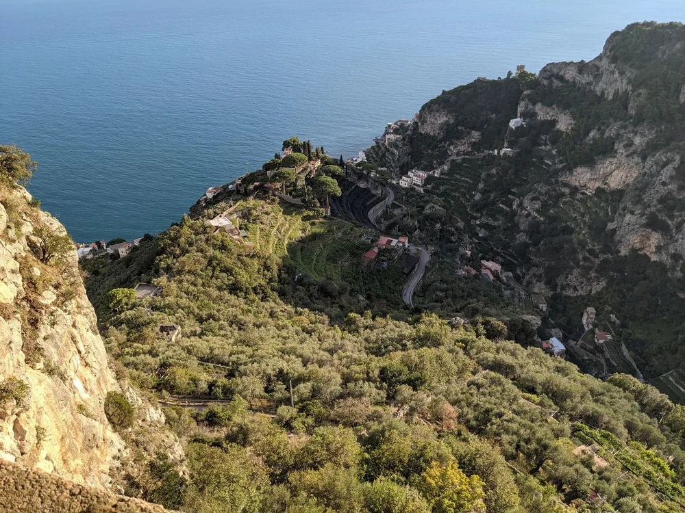 High-angle view of a coastal village nestled in lush greenery and cliffs