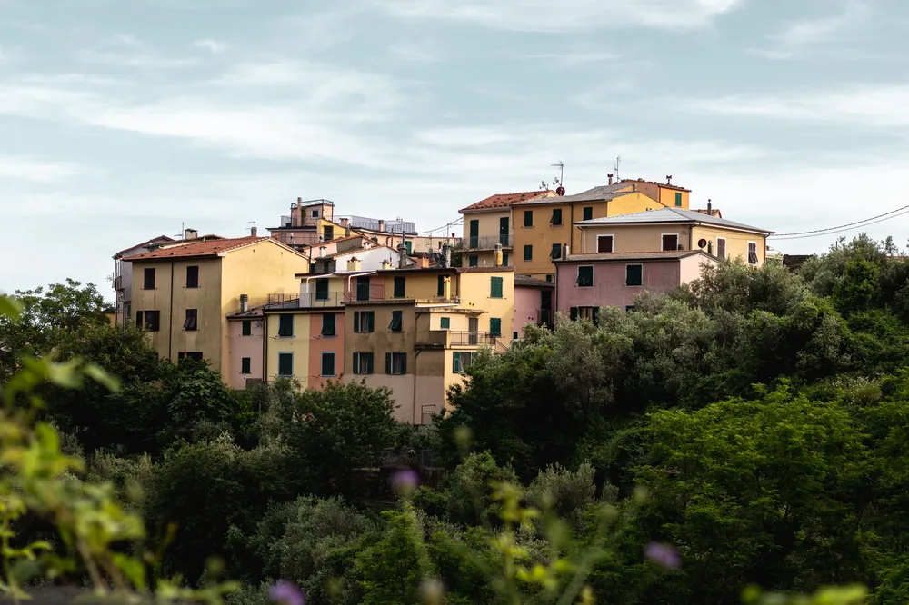 Hillside village with colorful buildings surrounded by lush greenery in summertime