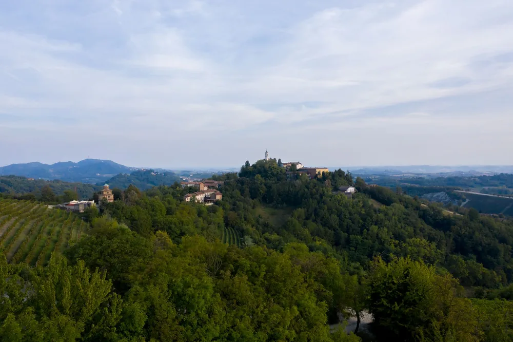 Hilltop village surrounded by lush greenery and expansive landscapes
