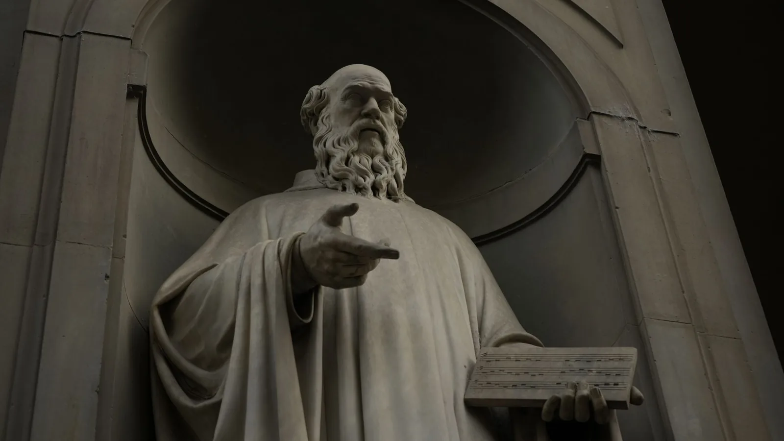 Historic marble statue of a bearded man holding a tablet