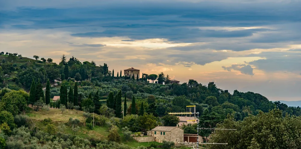 Idyllic Tuscan landscape with villas and lush greenery at dusk
