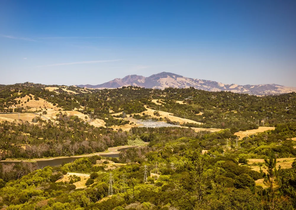 Landscape of rolling hills and distant mountains under a clear blue sky