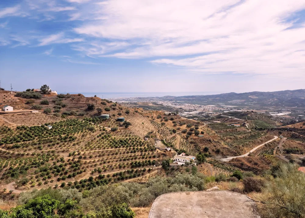 Landscape of Vélez-Málaga with hills and farmland under a clear sky