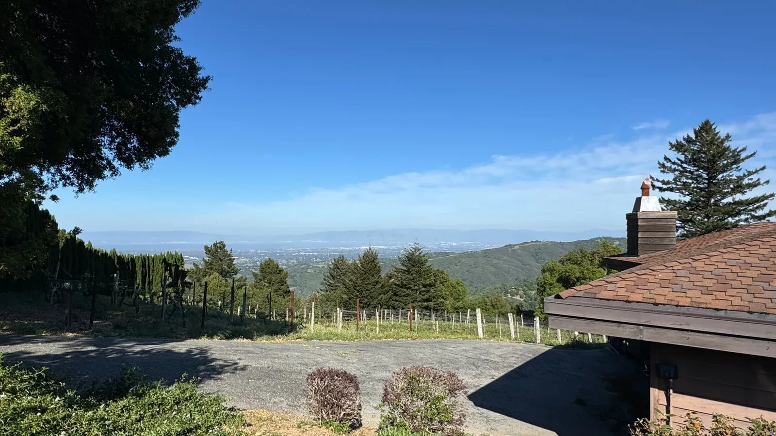 Landscape view over hills and vegetation in Woodside, California, under a clear blue sky