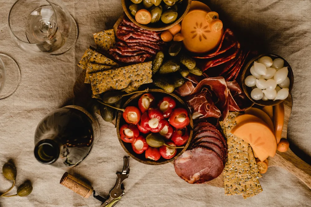 Luxurious charcuterie board with meats, cheeses, fruits, and wine, perfect for a gourmet dining experience