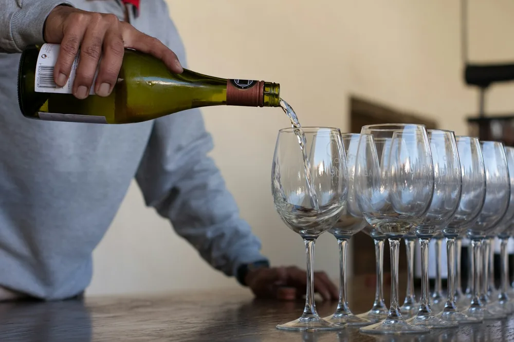 Man pouring champagne on clear drinking glass