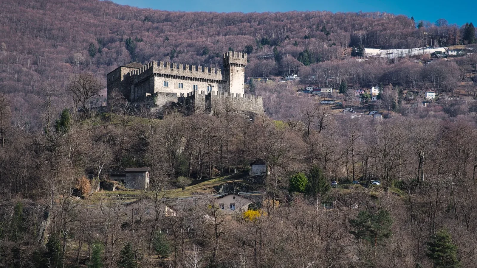 Medieval castle atop a hill with lush landscape, offering a glimpse into historical architecture