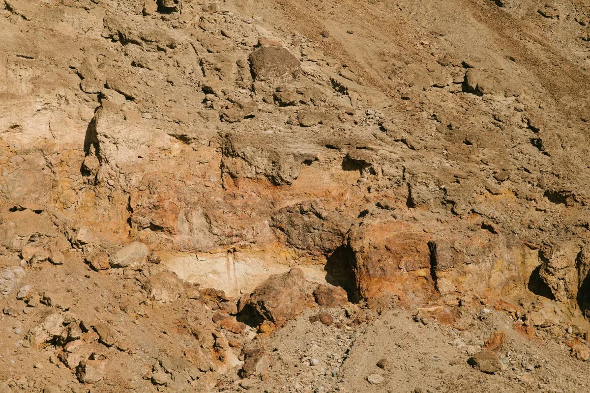 Rocky pale outcrop and thin dry soil on a high ridge above a distant valley