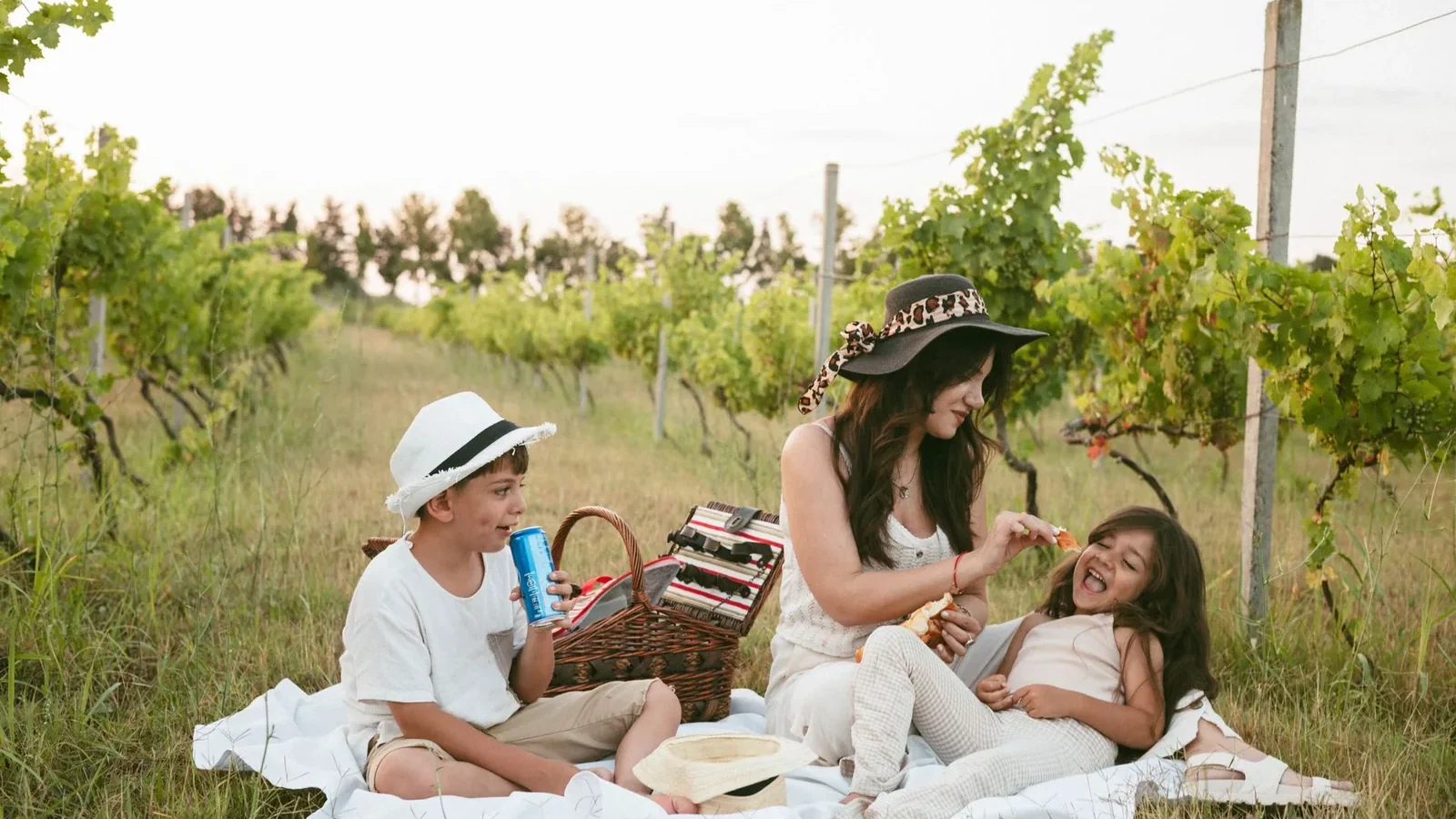 Mother and children enjoying a picnic in a scenic vineyard