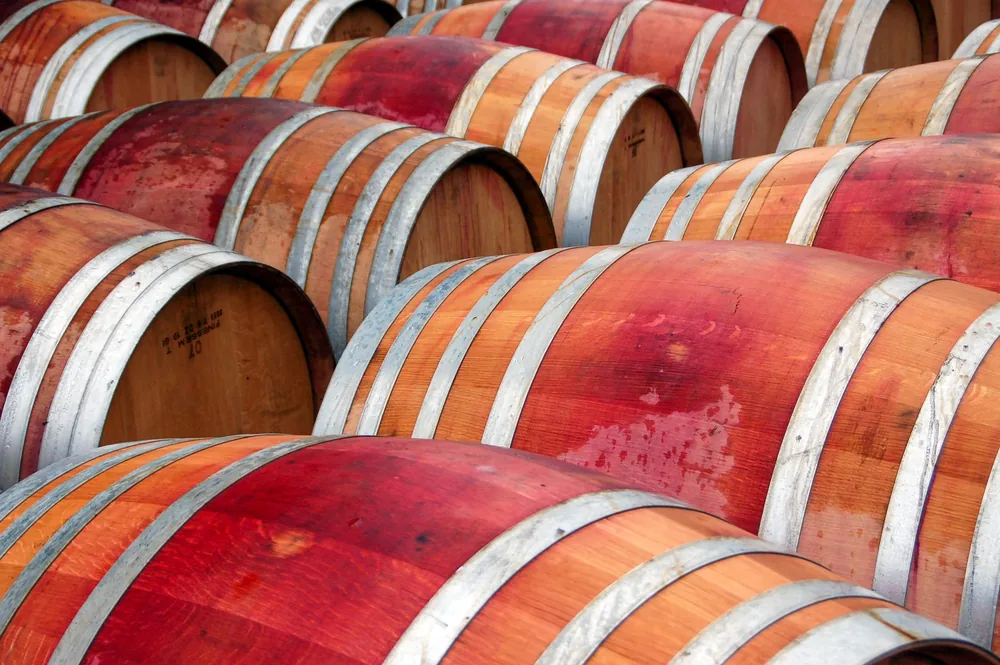 Multiple wooden wine barrels in a cellar, showing rustic texture
