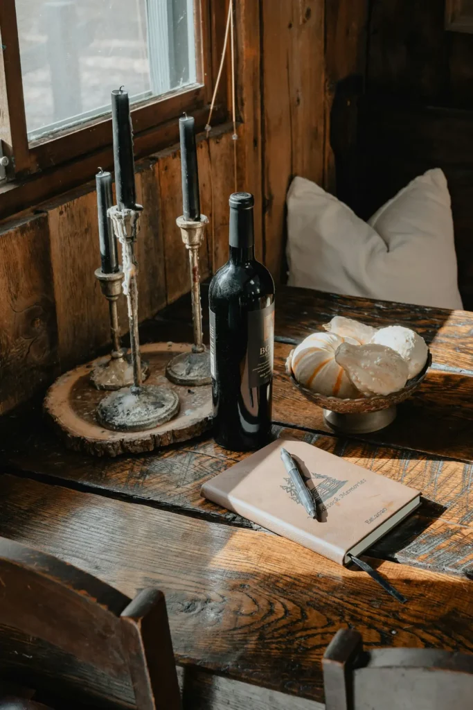 A tasting table with a bottle, candles and an open notebook