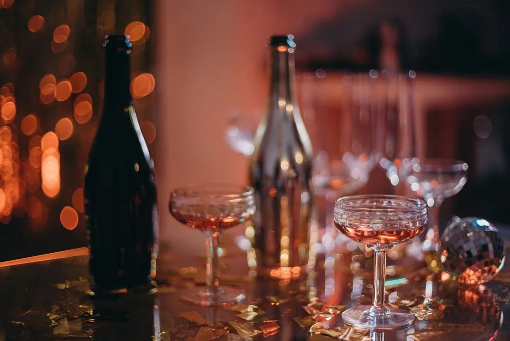 Party scene with champagne glasses, bokeh lights, and festive decorations