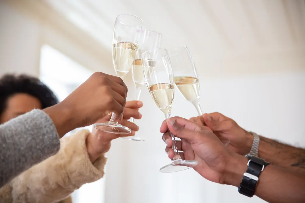 People raising champagne glasses for a celebratory toast indoors. Perfect for party themes