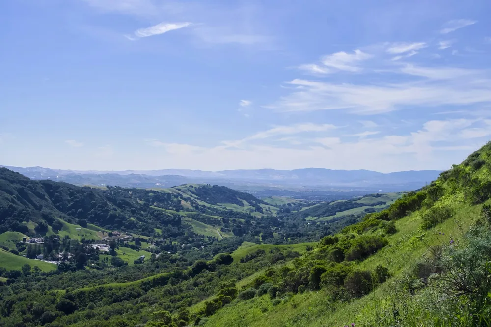 Rolling green hills under a blue sky with clouds