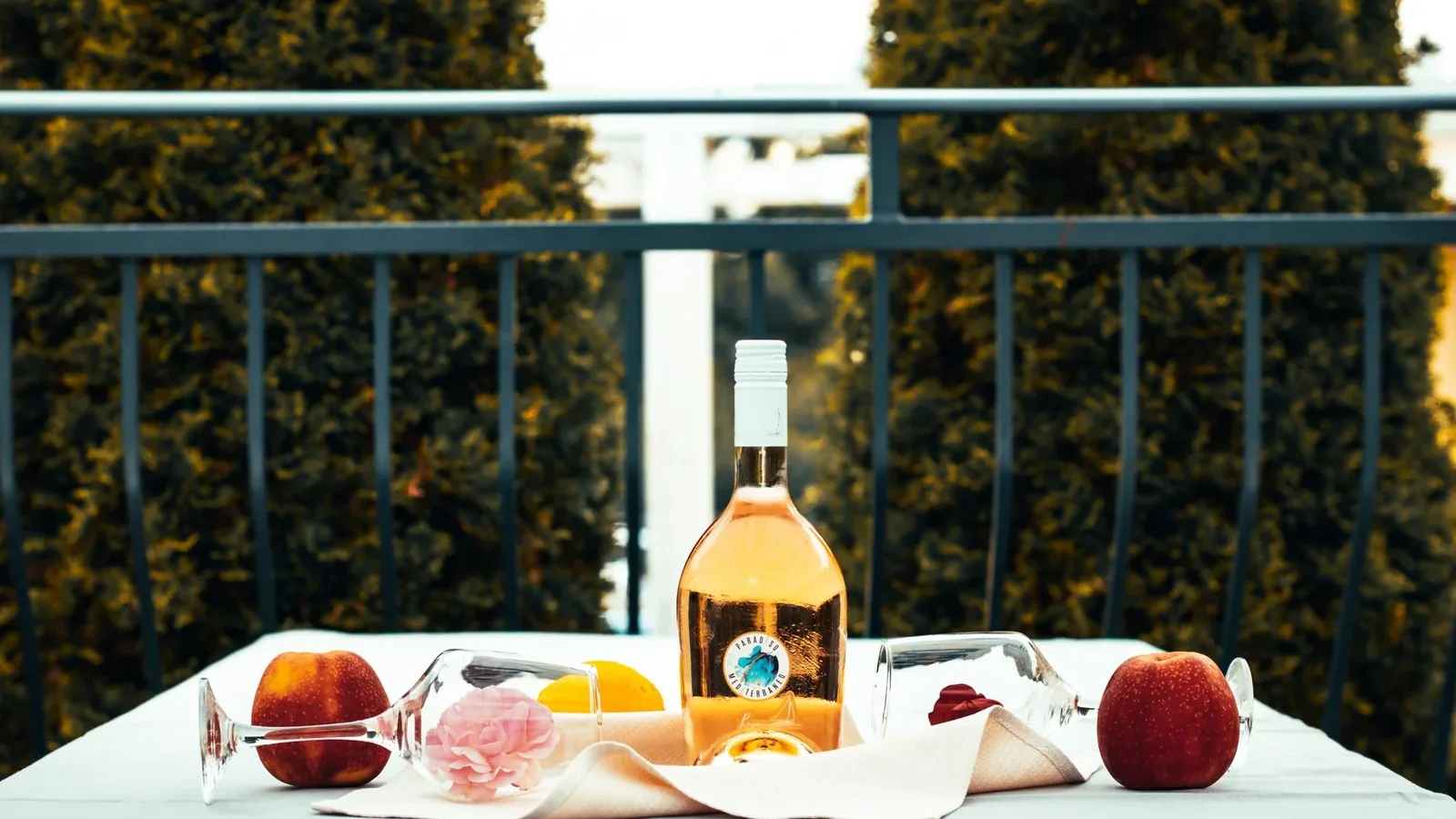Rosé wine bottle and fruits on a table outdoors creating a relaxed vibe