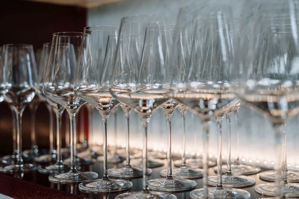 Row of crystal wine glasses neatly arranged on a shelf, highlighting elegance and luxury