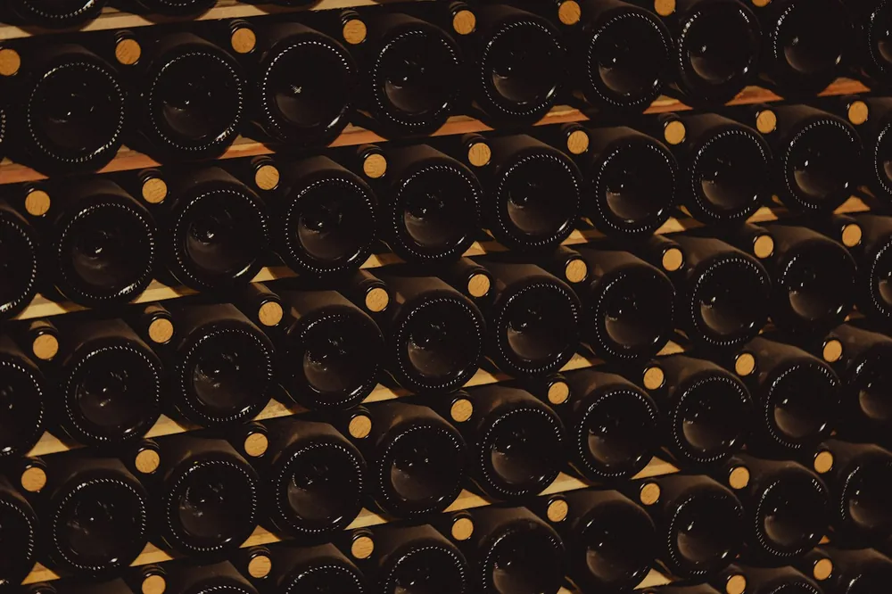 Rows of dark glass wine bottles stacked on shelves