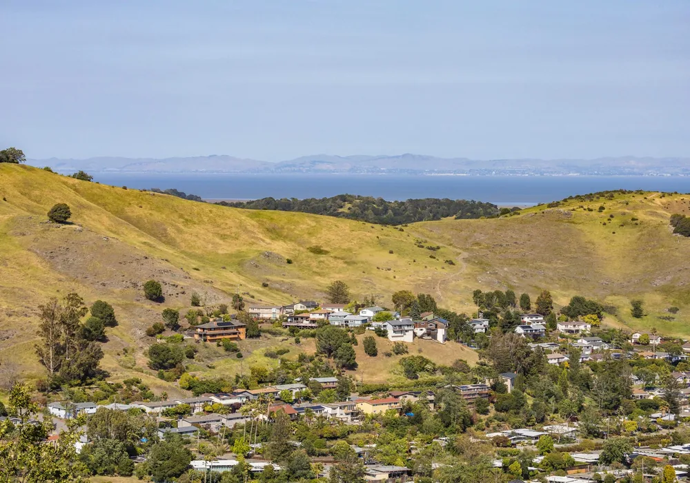 Rural landscape with hills, houses, and distant water