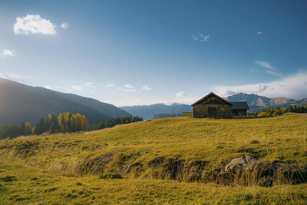 Rustic barn on a golden hill with distant mountains