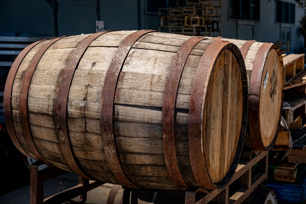 Rustic wooden barrels with metal bands on outdoor storage platform