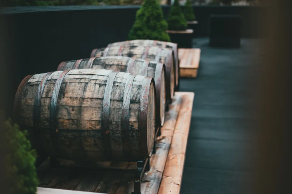 Rustic wooden wine barrels lined up on an outdoor patio setting, ideal for storage or decor
