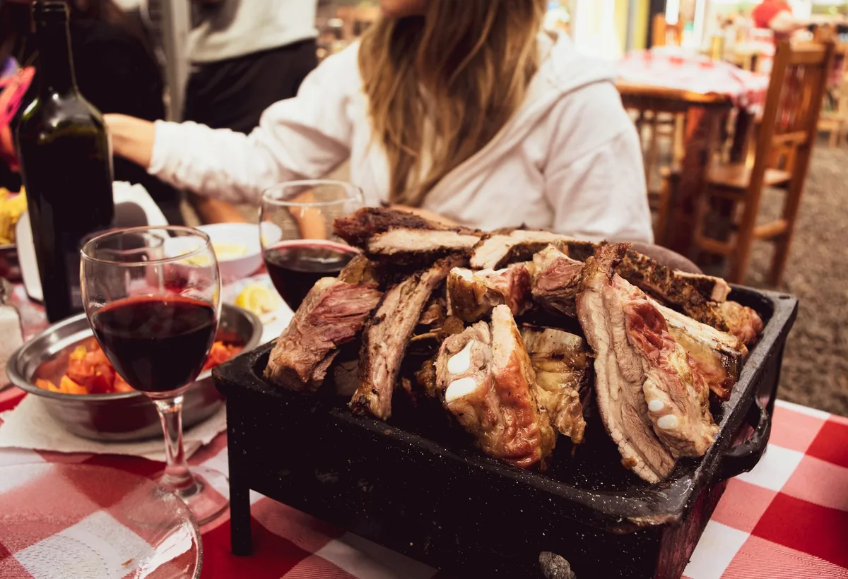 Appetizing BBQ ribs served with wine on a checkered table, capturing a cozy outdoor dining experience