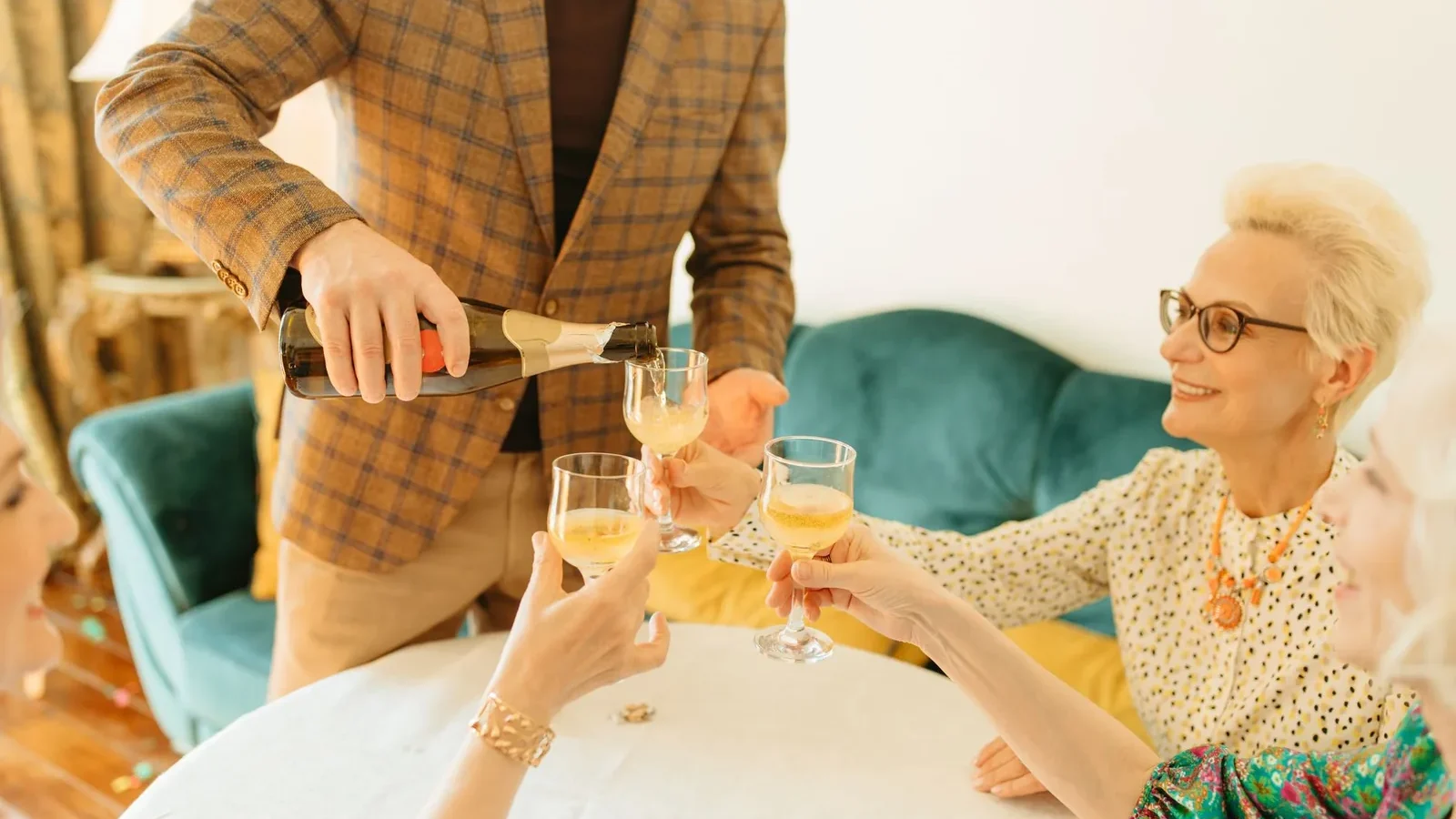 Senior adults sharing a champagne toast in a cozy indoor setting