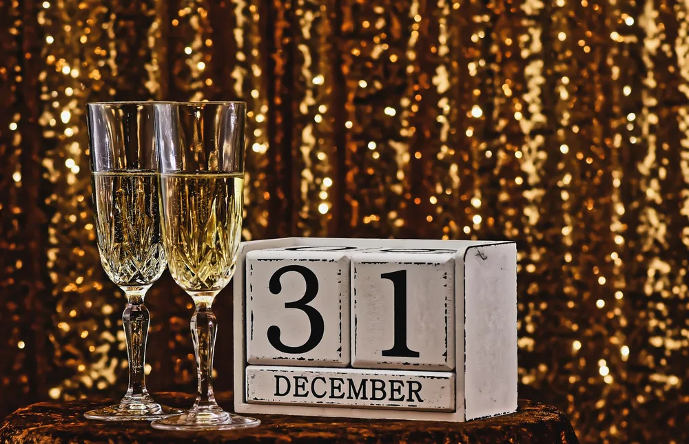 Sparkling champagne glasses with December 31st calendar block for New Year's Eve party