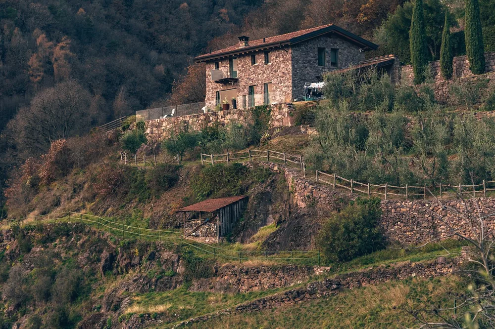 Stone house nestled on a hill with scenic autumn foliage. Tranquil countryside setting