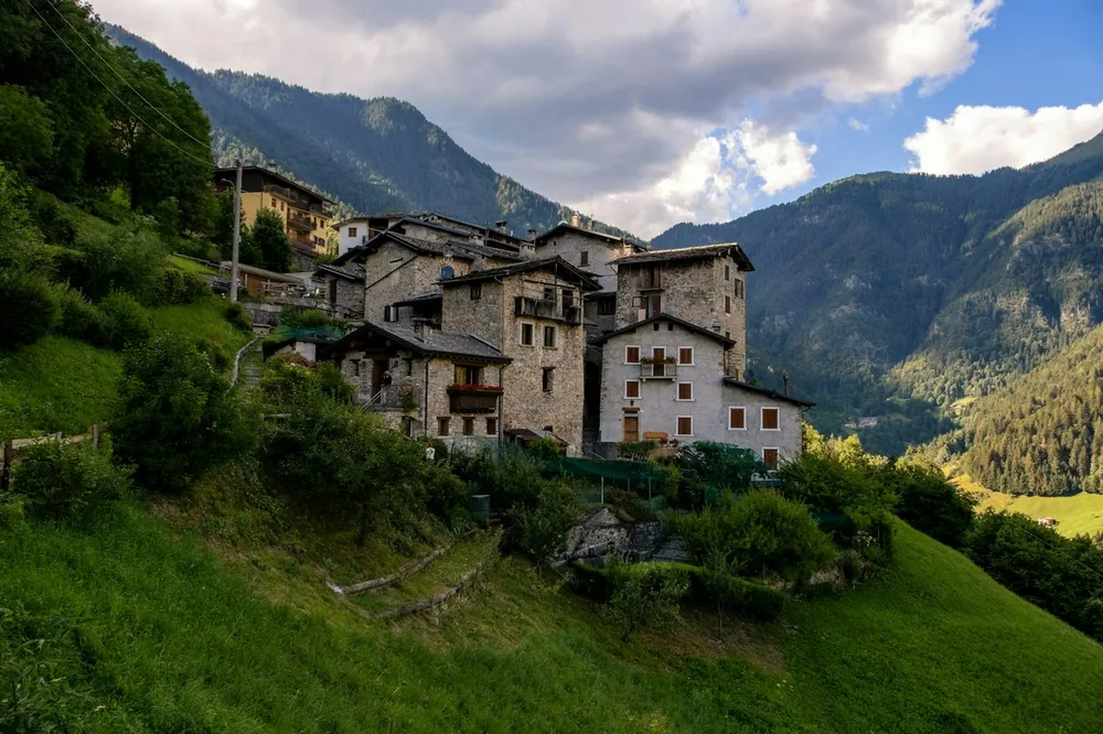Stone houses nestled on a green mountain slope