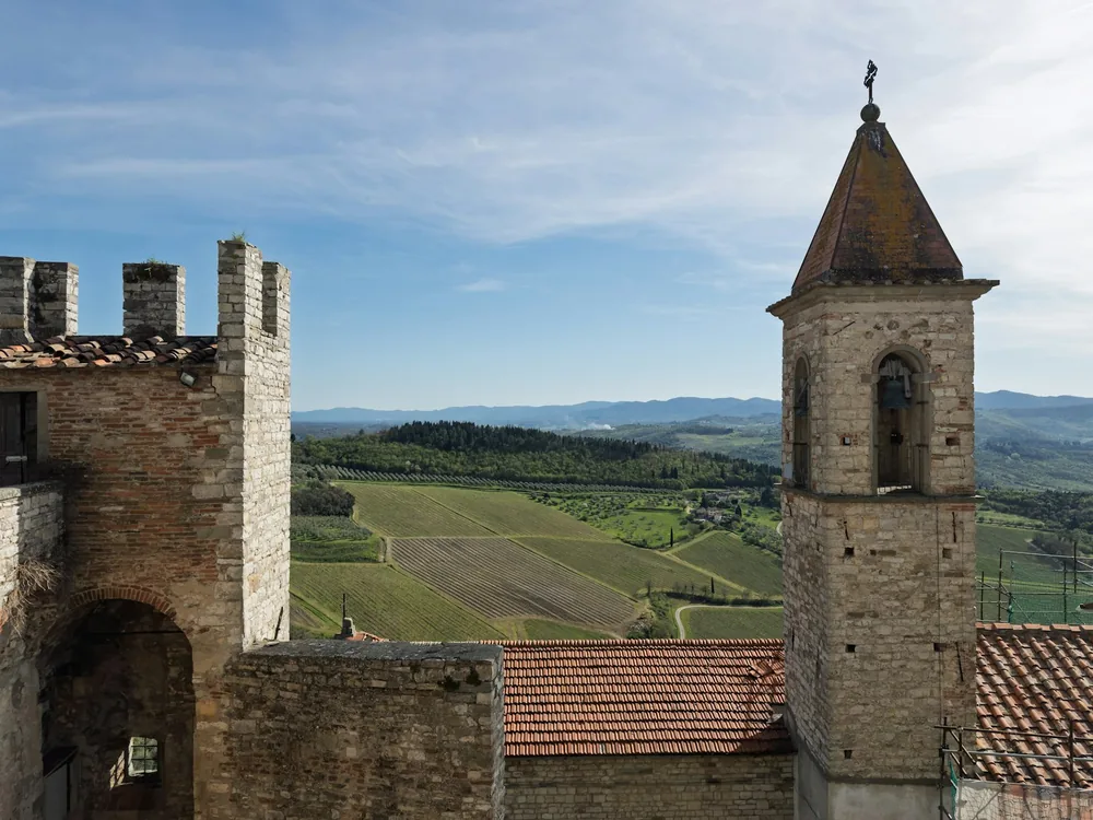 Stone tower and castle wall overlook rolling green hills
