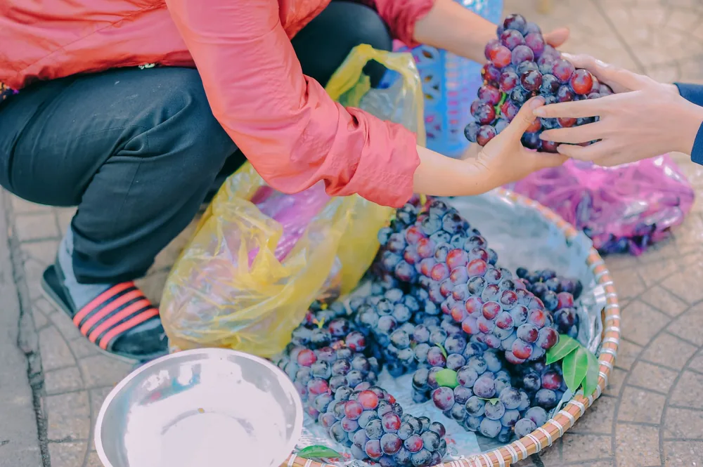 Street market scene with grapes being sold by a vendor. Perfect for lifestyle and food themes