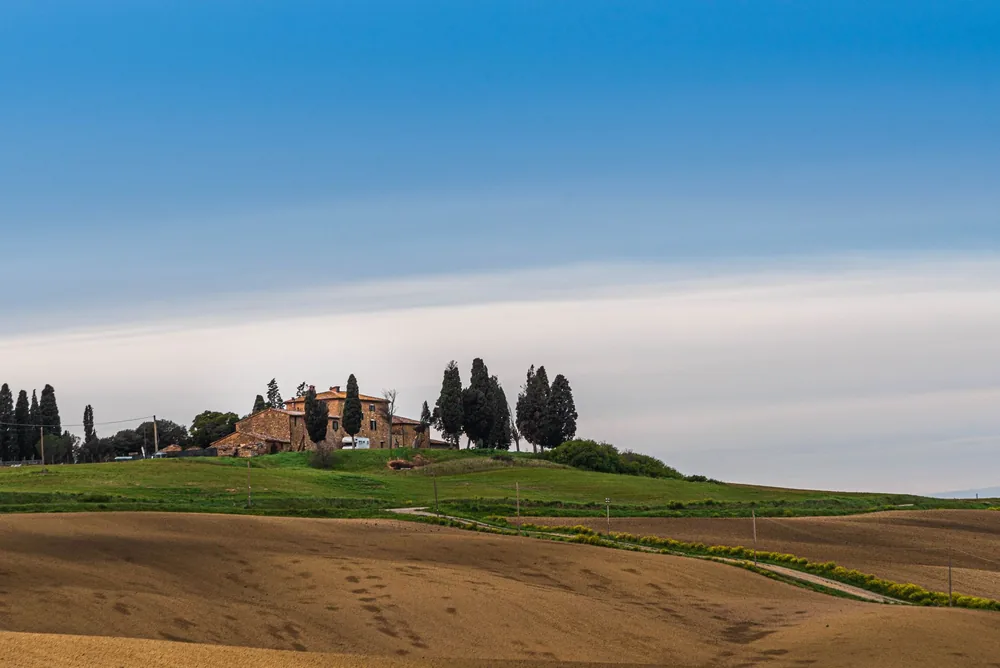 Tuscan landscape featuring a rustic farmhouse and rolling hills