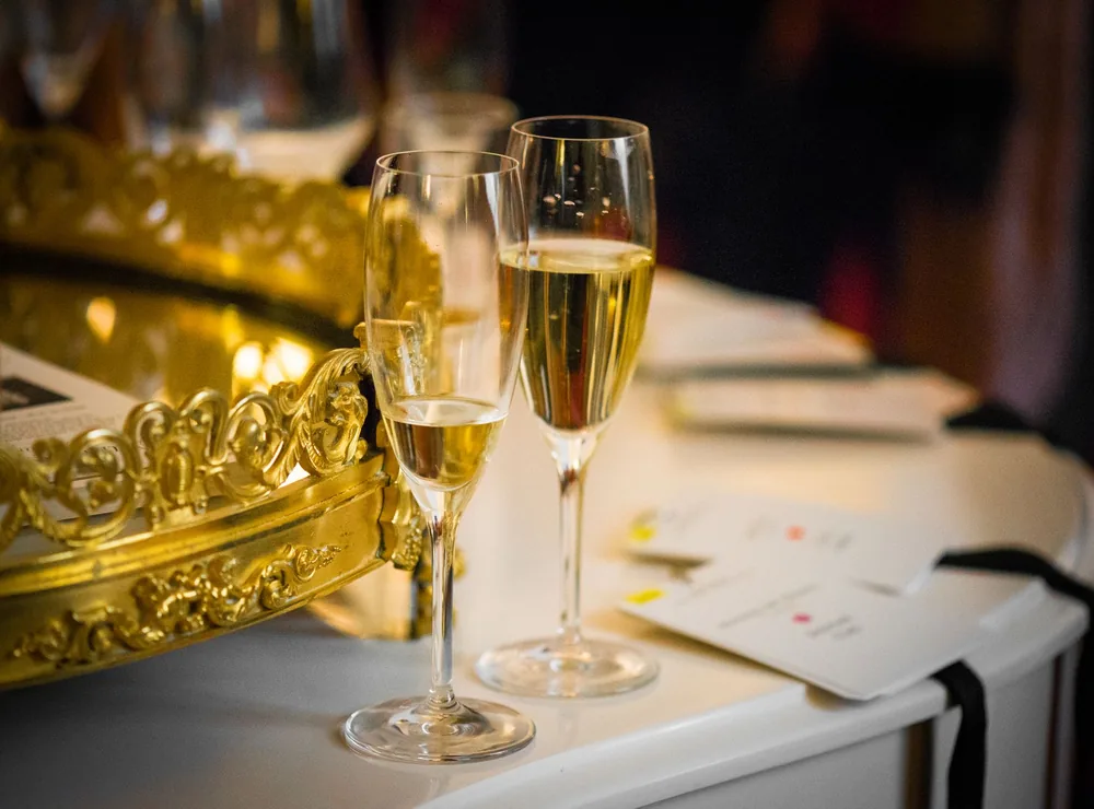 Two champagne glasses on a golden tray, set in a luxurious indoor setting, ideal for celebrations