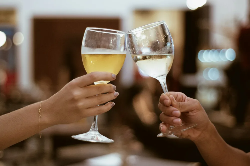 Two person toasting with wine glasses