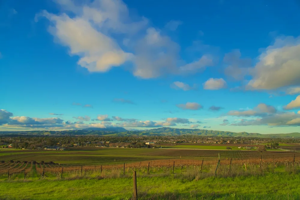 Vast landscape with rolling hills and scattered clouds
