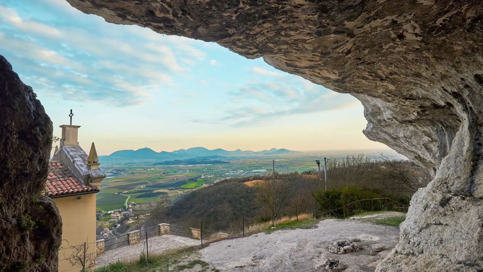 View over Villaga, Veneto, from inside a natural cave, showcasing panoramic landscapes and distant hills