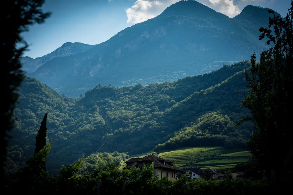Village nestled in a lush green valley surrounded by mountains, creating a serene natural landscape