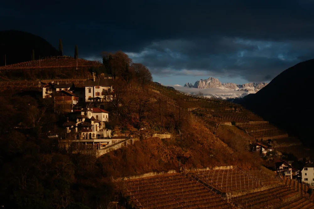 Village on a hill with dramatic mountains in twilight