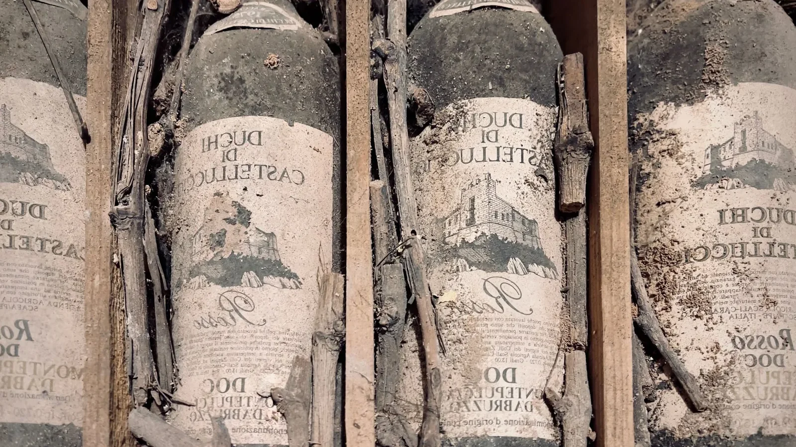 Vintage dusty wine bottles in a wooden crate, covered with dirt and sticks