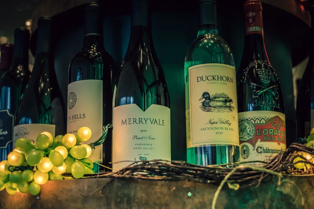 Wine bottles with green grapes, perfect for wine enthusiasts