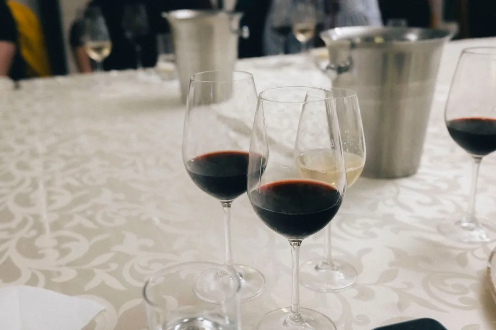 Wine glasses on a table set for an elegant wine tasting event indoors with a classy tablecloth