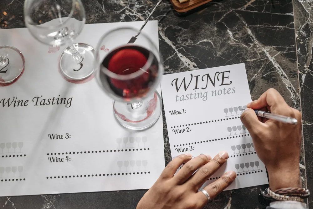 Wine tasting session with notes, glasses, and marble surface