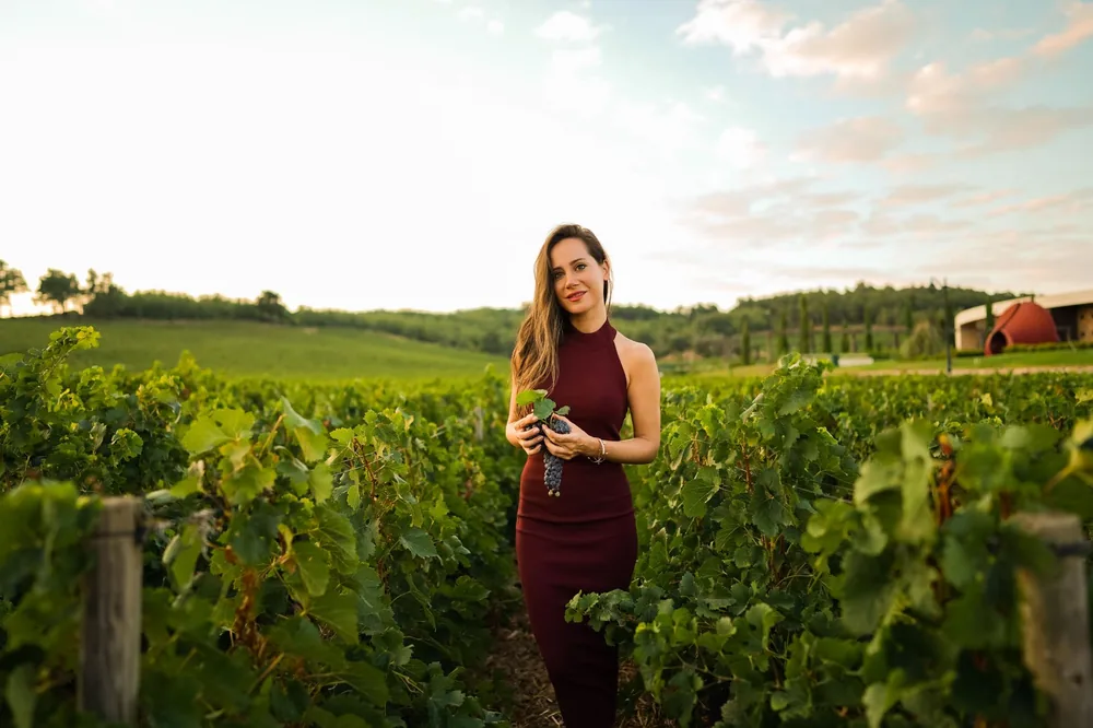 Woman holding grapes in a vineyard in Çanakkale, Türkiye
